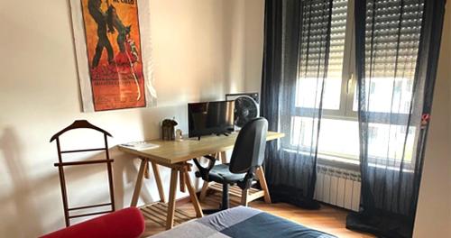einen Schreibtisch mit einem Computer und einem Stuhl in einem Zimmer in der Unterkunft B&B Stanze Lussuose in Aversa