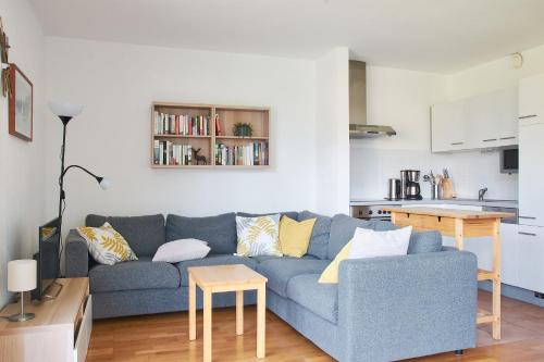a living room with a blue couch and a kitchen at Mountain View Ski Apartment Rauris in Rauris