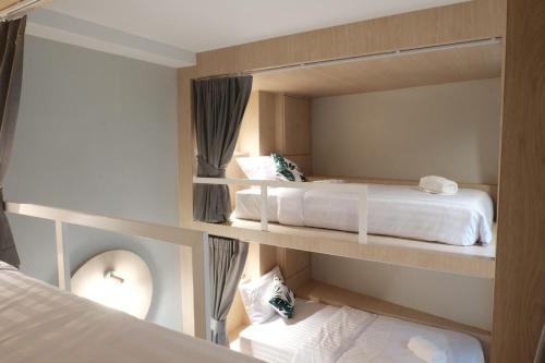 een slaapkamer met 2 bedden en een spiegel bij THE BELONG BOUTIQUE HOTEL in Phuket