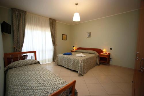 1 dormitorio con 2 camas y ventana en B&B Villa Maria, en Catanzaro