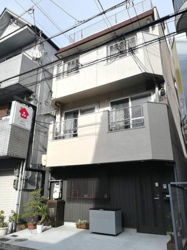 a white building with windows and a fence at U-shuku Kyoto Fushimi in Momoyama-chō