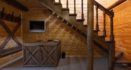 a staircase in a log cabin with a tv on the wall at Shale Verba in Kvasy