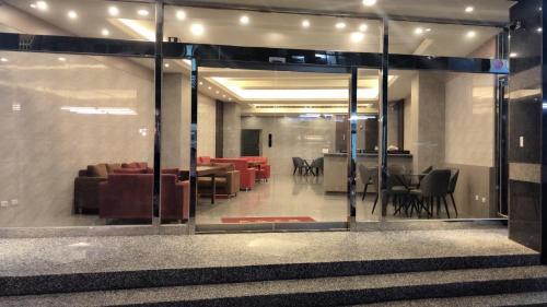 a lobby with a glass door with chairs and tables at Jin Zhan Hotel in Jincheng
