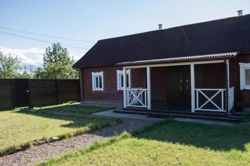 a red house with white doors and a fence at "Дальний кордон" in Moshchanytsya