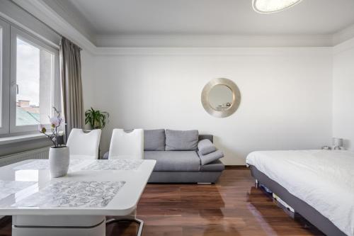 a white bedroom with a bed and a couch at Breathless view Synagogue elegant apartment FREE PARKING RESERVATION NEEDED in Budapest