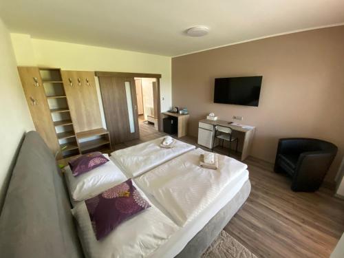 a hotel room with a bed and a flat screen tv at Penzion Čavisov in Čavisov
