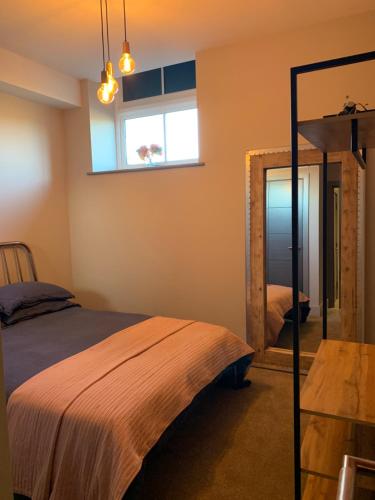 a bedroom with a bed and a mirror at Oddfellows Hall in Thetford