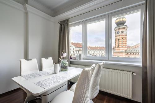a dining room with a table and chairs and a window at Breathless view Synagogue elegant apartment FREE PARKING RESERVATION NEEDED in Budapest