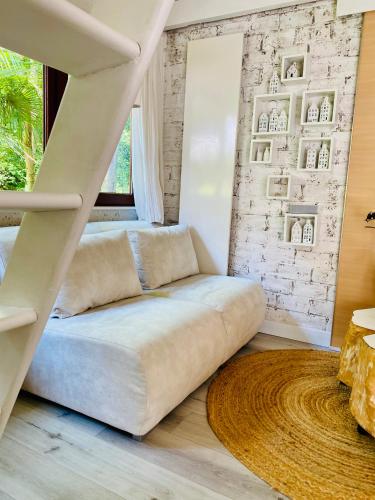a white couch in a room with a staircase at Casa De Palmas - Tiny house in Alkmaar