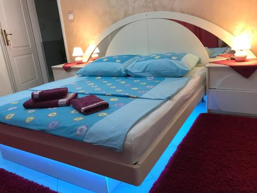 - une chambre dotée d'un lit avec des lumières bleues dans l'établissement Guesthouse Rebel, à Deliblato
