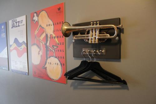 a brass trumpet hanging on a wall with posters at Lillehammer Stasjonen Hotel in Lillehammer