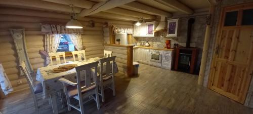 a kitchen with a table and chairs in a room at Domek Nad River San - pierwsza linia brzegowa - balia - łodzie - basen in Olchowiec