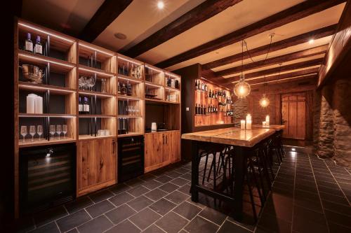 a kitchen with wooden cabinets and a bar with stools at 5th Floor Basic Rooms - shared bathrooms in Interlaken