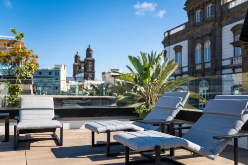 a row of chairs and tables in front of a large building at Boutique Hotel Cordial La Peregrina in Las Palmas de Gran Canaria