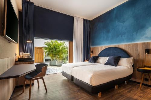 um quarto com uma cama, uma secretária e uma janela em Boutique Hotel Cordial La Peregrina em Las Palmas de Gran Canaria