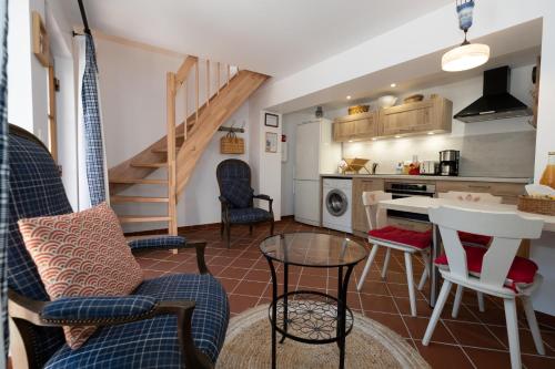 ein Wohnzimmer mit einem Tisch und Stühlen sowie eine Küche in der Unterkunft Les Tilleuls in Wissembourg