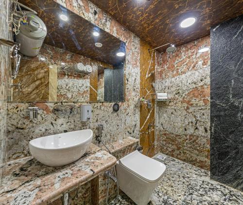 uma casa de banho com um lavatório e um WC em Hotel Blooming Soul em Kolhapur