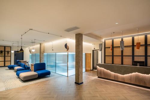 un hall avec des chaises bleues et une salle d'attente dans l'établissement Boutique Hotel Cordial La Peregrina, à Las Palmas de Gran Canaria