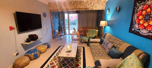 a living room with a couch and a flat screen tv at Palermo Chalet in Marina Wadi Degla Ain Sokhna with 250 Sqm Private Garden & near to the Beach in Ain Sokhna
