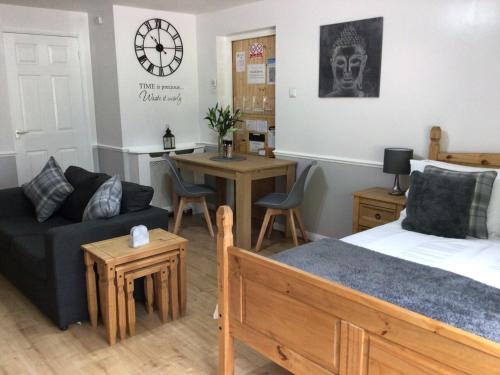 a bedroom with a bed and a living room at Meerkat Manor in Coddington