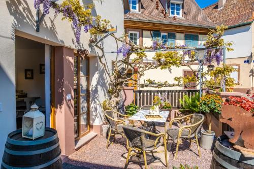 a patio with a table and chairs and flowers at Les Tilleuls in Wissembourg