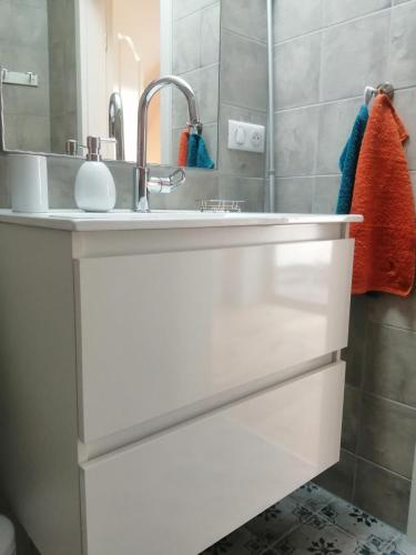 une salle de bain avec un lavabo blanc et un miroir dans l'établissement Les Tilleuls, à Wissembourg