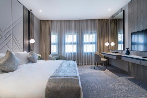 a hotel room with a large bed and a desk at Vittori Palace Hotel and Residences in Riyadh