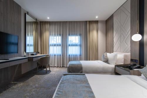 a hotel room with two beds and a television at Vittori Palace Hotel and Residences in Riyadh
