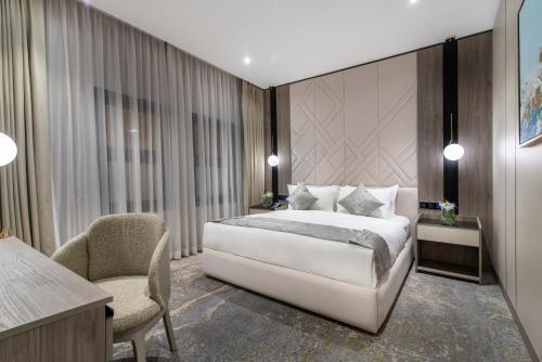 a bedroom with a bed and a desk and a chair at Vittori Palace Hotel and Residences in Riyadh