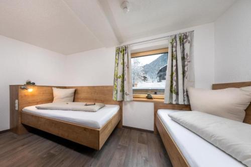 a bedroom with two beds and a window at Haus Sabrina Rotpleiskopf in See