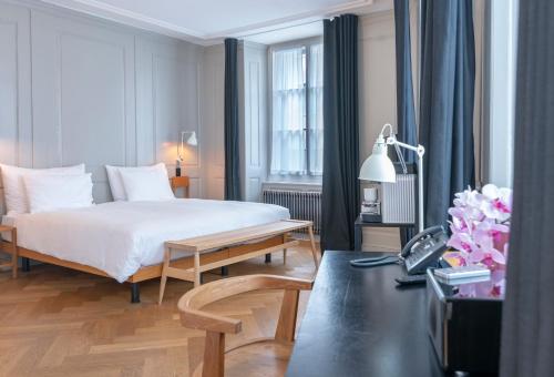 1 dormitorio con cama, mesa y ventana en Marktgasse Hotel, en Zúrich