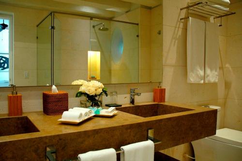 
a bathroom with a sink, mirror, towels and a towel rack at Hotel Casa Don Sancho By Mustique in Cartagena de Indias
