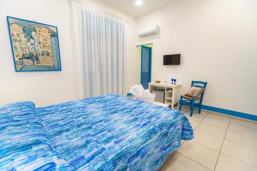 Un dormitorio con una cama, un escritorio y una silla. en Biù b&b, en Castellammare di Stabia