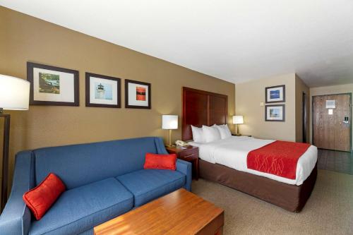 a hotel room with a bed and a blue couch at Comfort Inn River's Edge in Huron