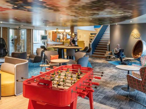 a living room with a chess board on a table at Hôtel Novotel Valenciennes in Valenciennes