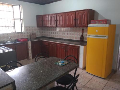 uma cozinha com uma mesa e um frigorífico amarelo em Suíte agradável no centro da cidade. em Boa Vista