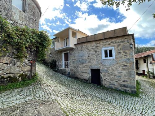 a stone building on a cobblestone street at Aroucanatur, Casa de Montanha in Arouca