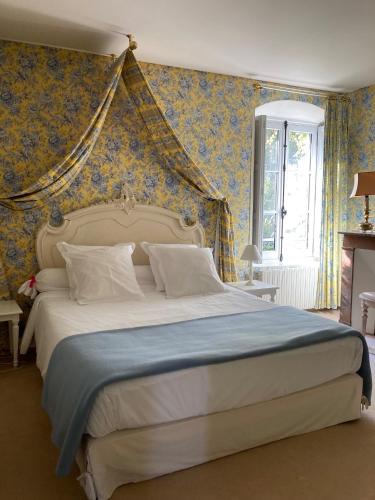 - une chambre avec un grand lit et du papier peint bleu dans l'établissement Château de Ré, à Le Petit-Pressigny