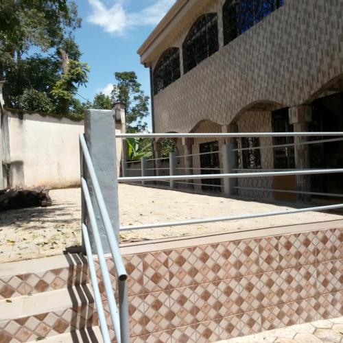 a fence in front of a building at RESIDENCE DU PELERIN - Villa l'écrin de verdure à Bandjoun in Bandjoun