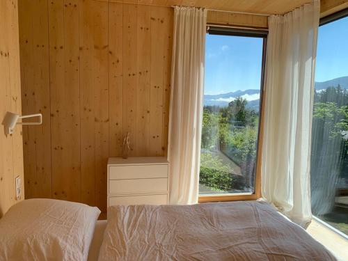 a bedroom with a bed and a large window at Modern & Homely Nature-Apartemt in Ramsau am Dachstein