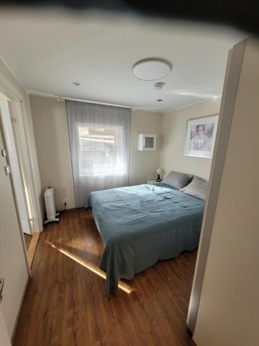 1 dormitorio con 1 cama en una habitación con suelo de madera en Espeland, en Bergen