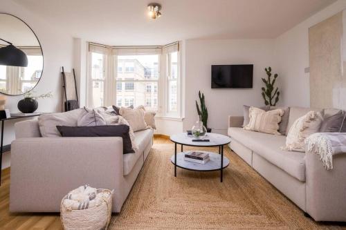 Sala de estar con 2 sofás y mesa en Beautifully styled, central apartment sleeping 10, en Brighton & Hove