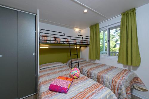 two beds in a room with a bunk bed at Camping Village Pino Mare in Lignano Sabbiadoro