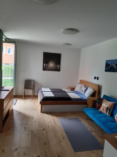 um quarto com uma cama e um sofá azul em Vila Zuberec apartmán 105 em Zuberec