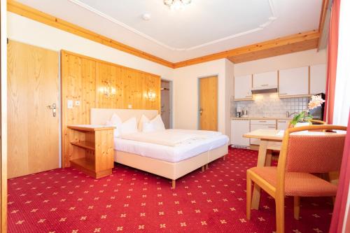 a bedroom with a bed and a table and a kitchen at Appartement Schöne Aussicht in Saalbach Hinterglemm