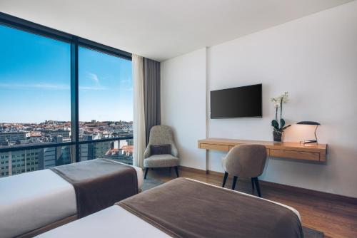 a hotel room with a desk and a view at Iberostar Selection Lisboa in Lisbon