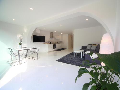 a white living room with a table and a couch at Vila Edelweiss Rooms&App Kranjska Gora in Kranjska Gora