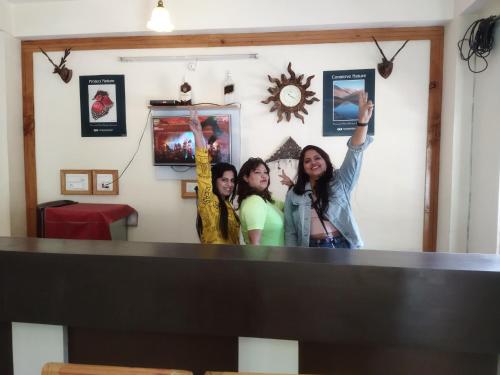 a group of three women standing in front of a mirror at Orange sky home stay gadaGushaini near jibhi in Jibhi