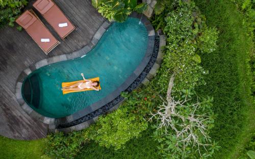 
a boat sitting on top of a lush green field at Madani Antique Villas in Ubud

