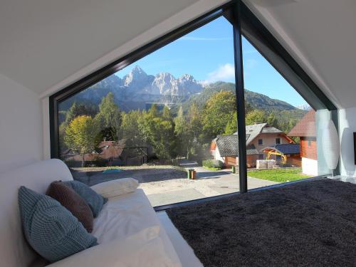 a living room with a couch and a large window at Vila Edelweiss Rooms&App Kranjska Gora in Kranjska Gora